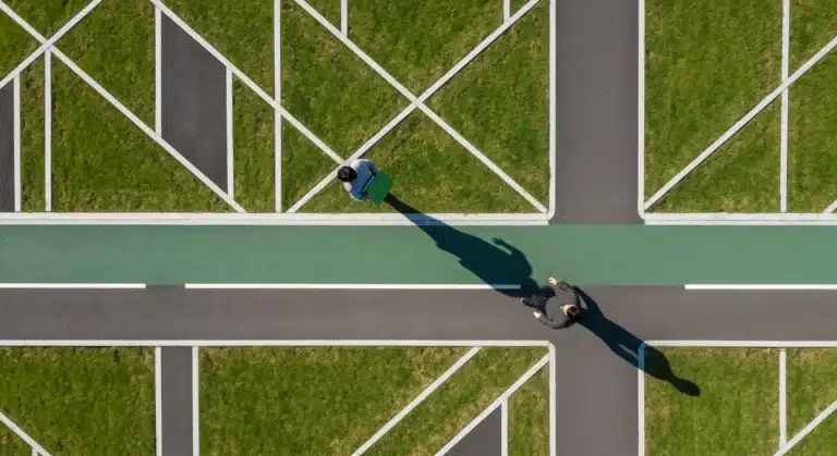 Aerial view of a person navigating a geometrically patterned urban park pathway, symbolizing complex talent marketing strategies for modern workforce engagement.